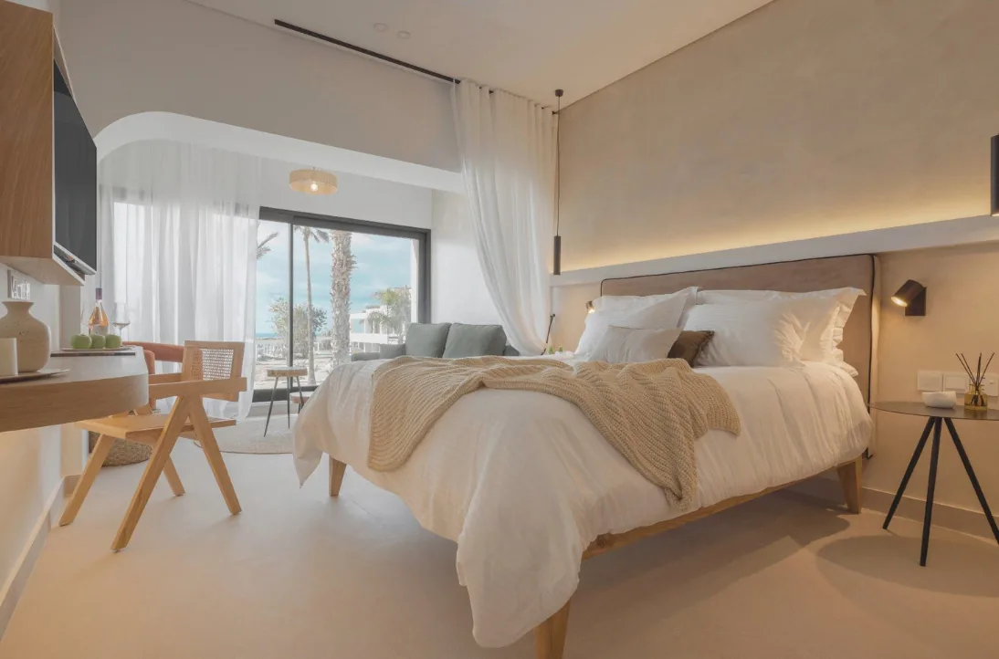 Chambre lumineuse du Brown Paphos Hills avec grande baie vitrée et lit king size