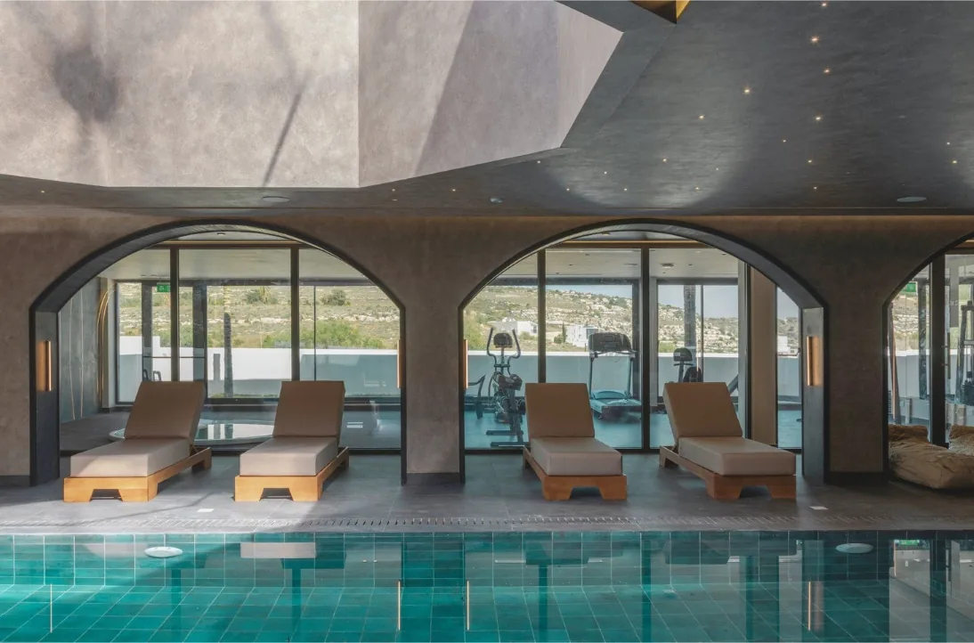 Espace détente du spa avec arches, transats et piscine intérieure