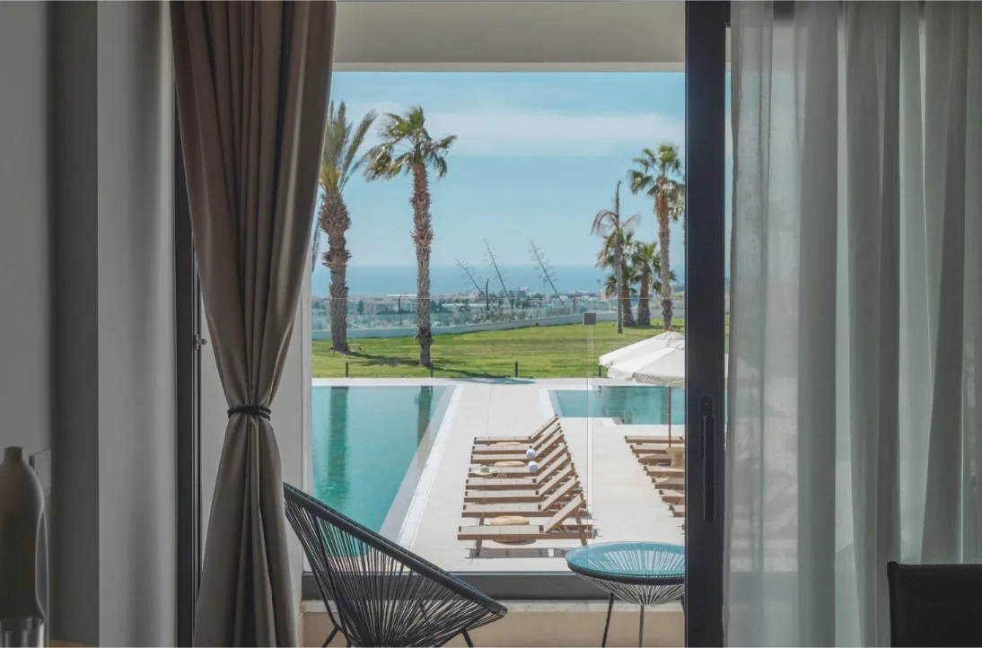 Vue depuis une suite du Paphos Hills sur sa piscine privée et les palmiers
